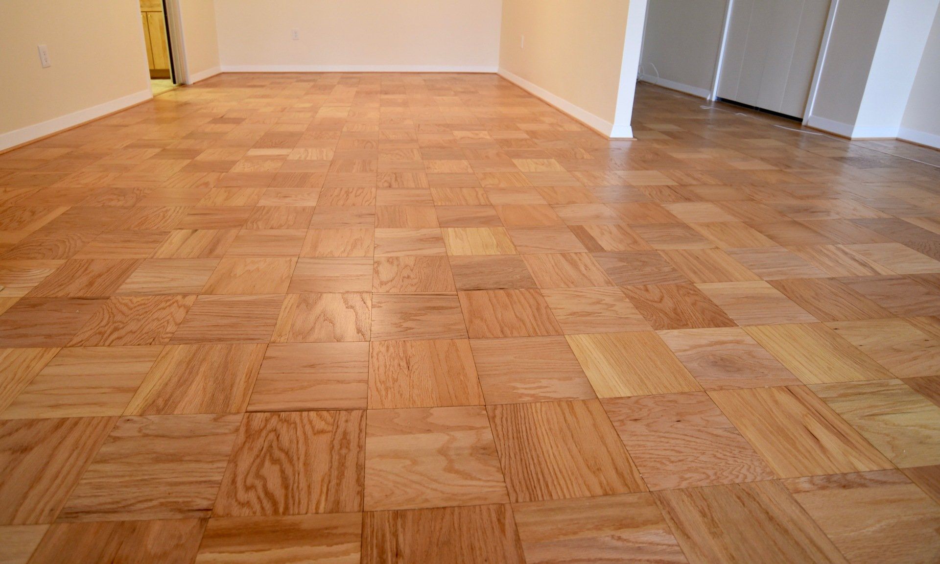 An empty room with a wooden floor and white walls