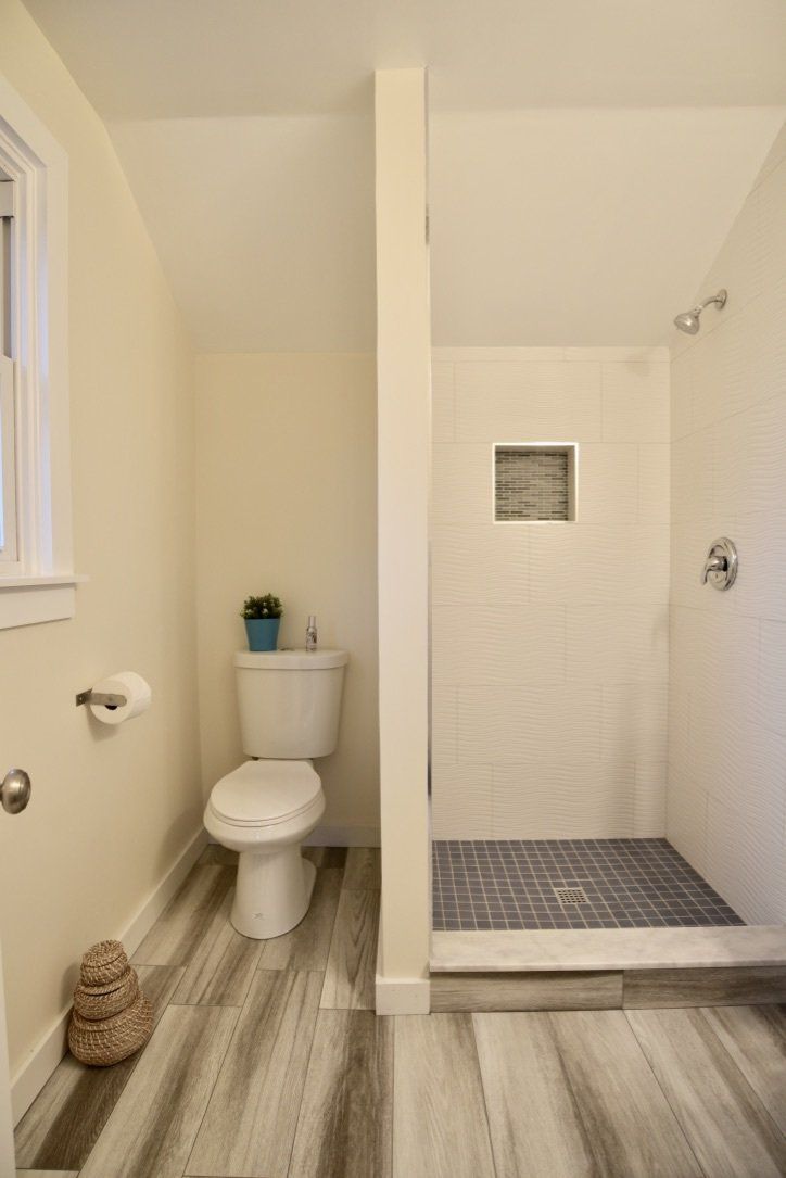 A bathroom with a toilet and a walk in shower.