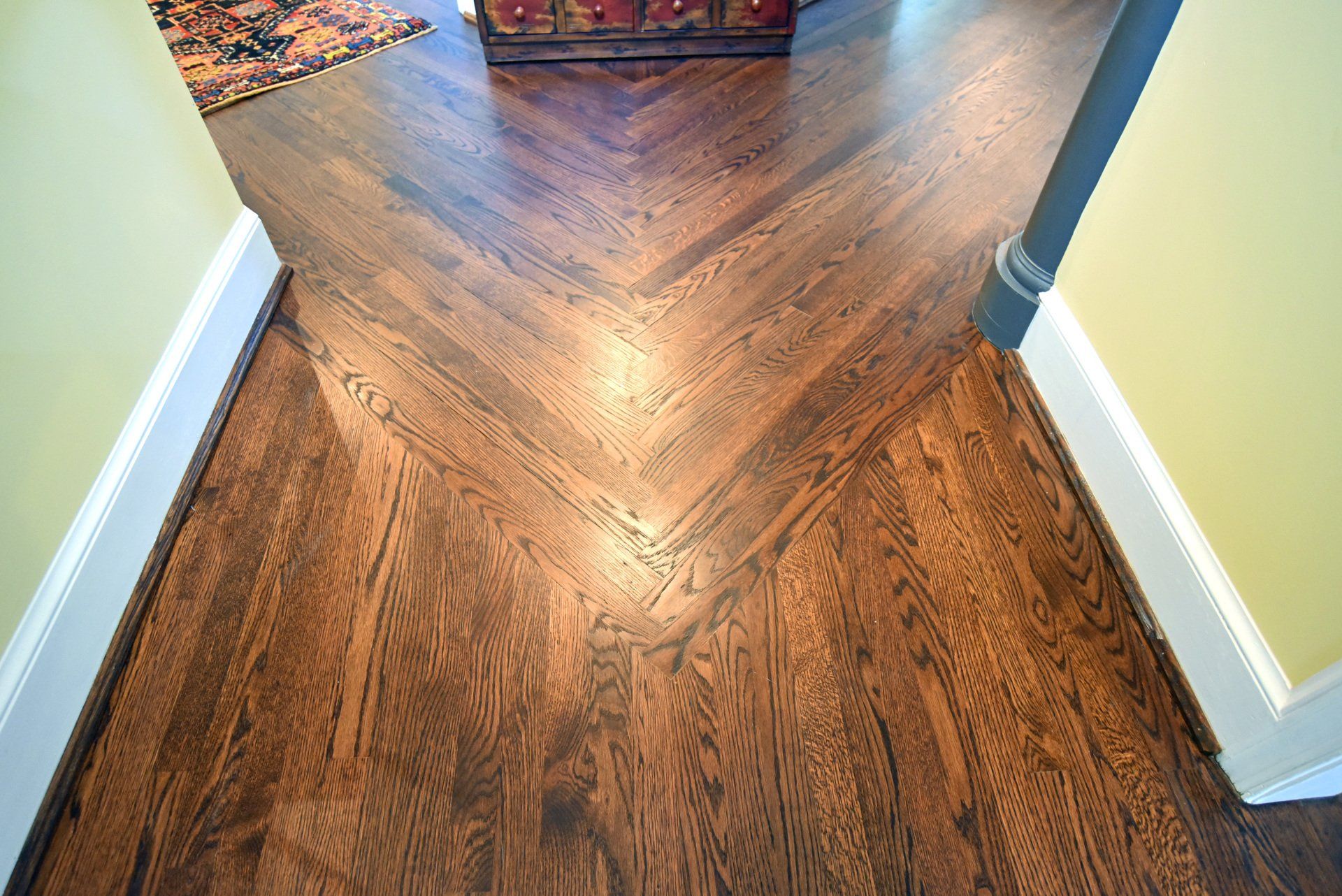 A wooden floor with a chevron pattern in a hallway