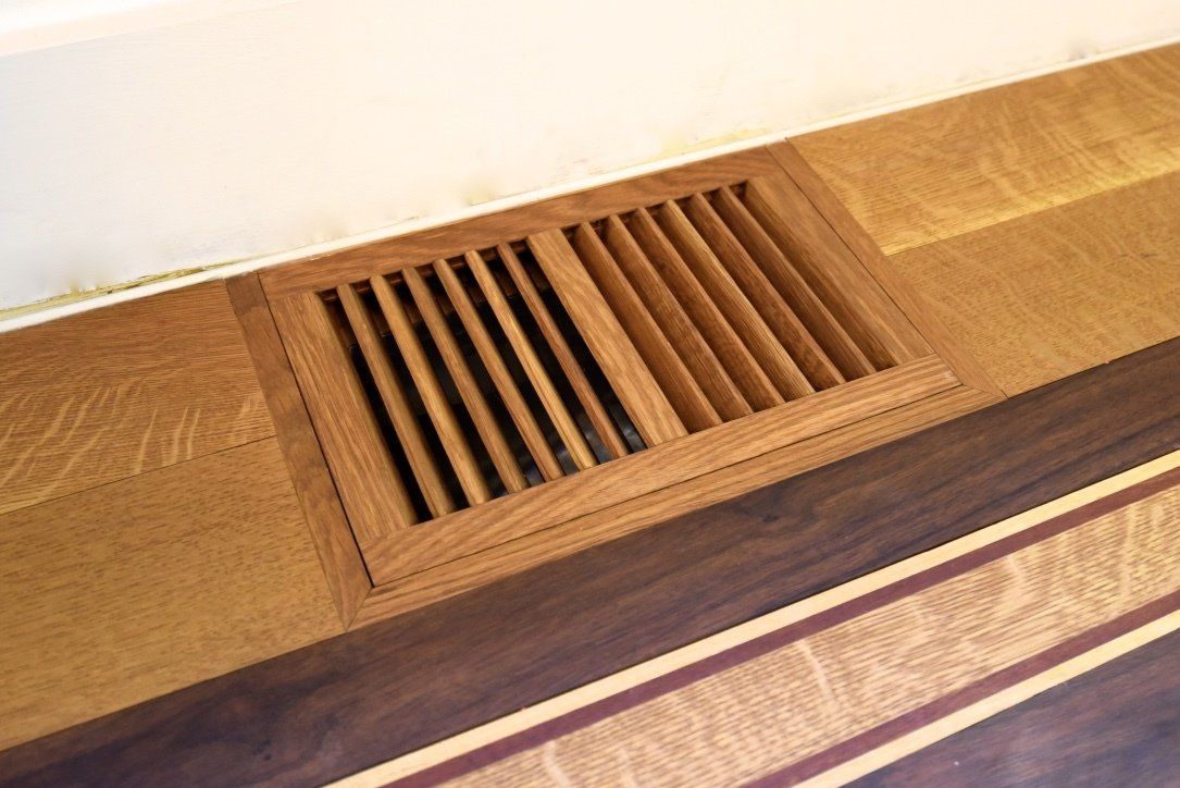 A wooden air vent on a wooden floor