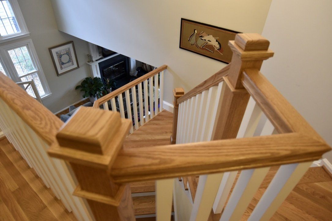 A wooden staircase with a white railing leading up to a living room