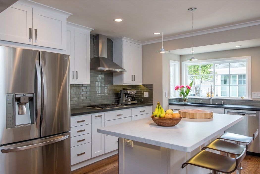 A kitchen with stainless steel appliances and white cabinets