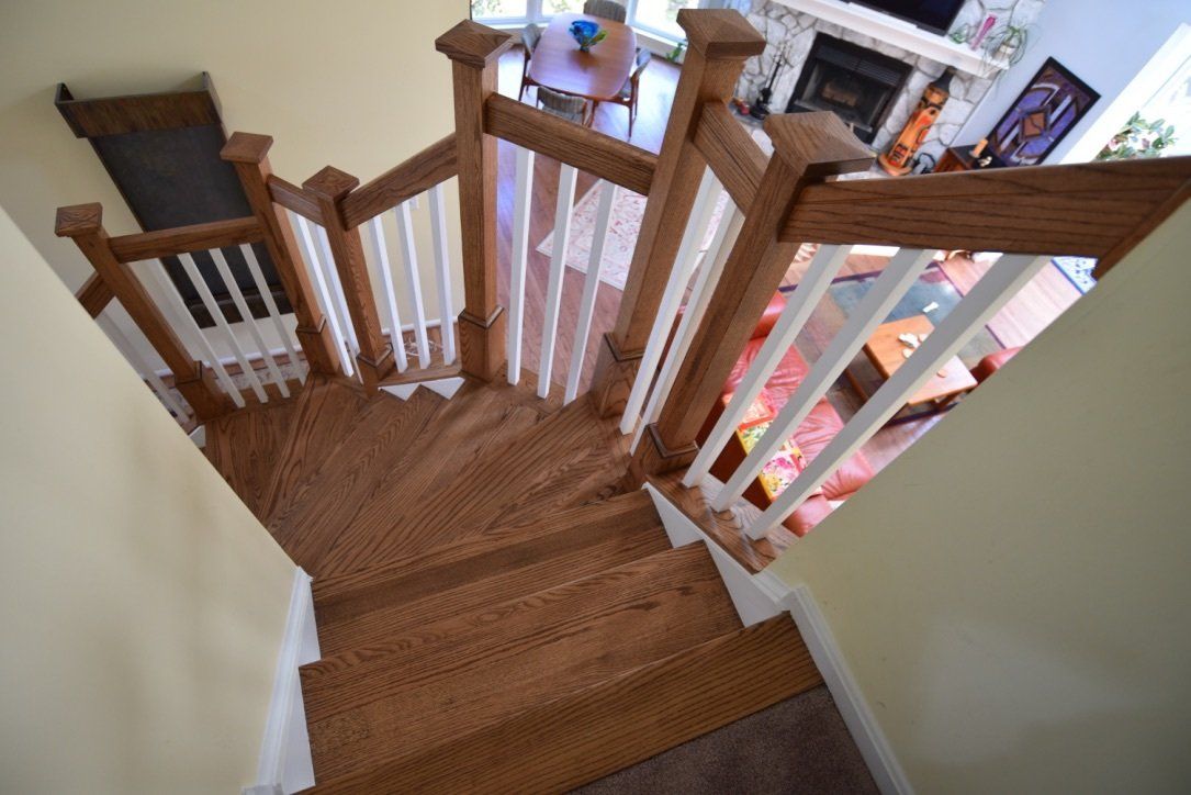 A wooden staircase with a white railing leading up to a living room