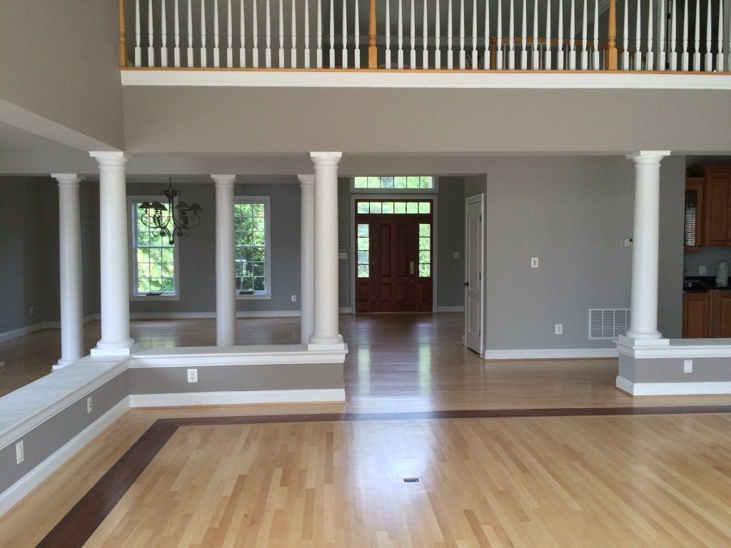 An empty house with hardwood floors and columns