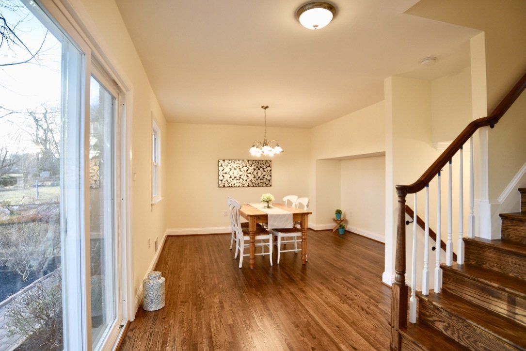 A dining room with a table and chairs and stairs
