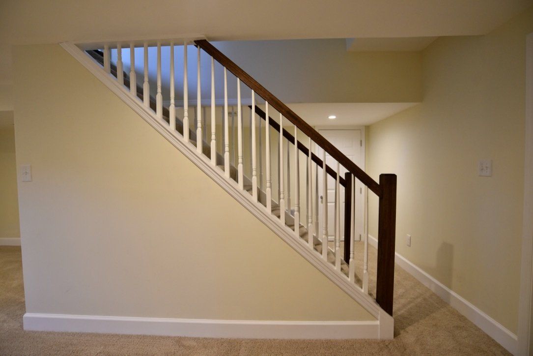 A staircase with a wooden railing in an empty room