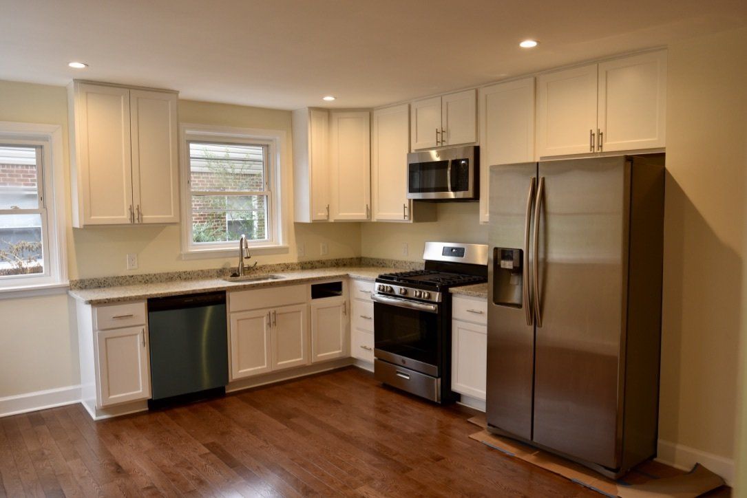 A kitchen with stainless steel appliances and white cabinets