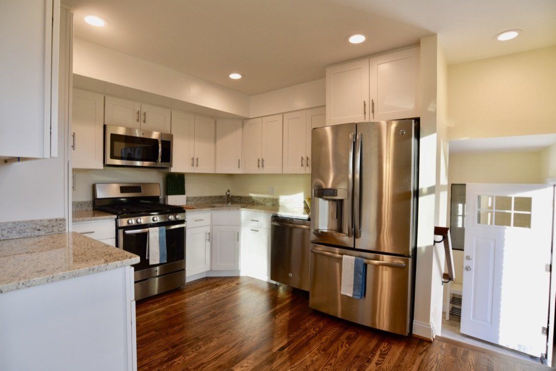 A kitchen with stainless steel appliances and white cabinets