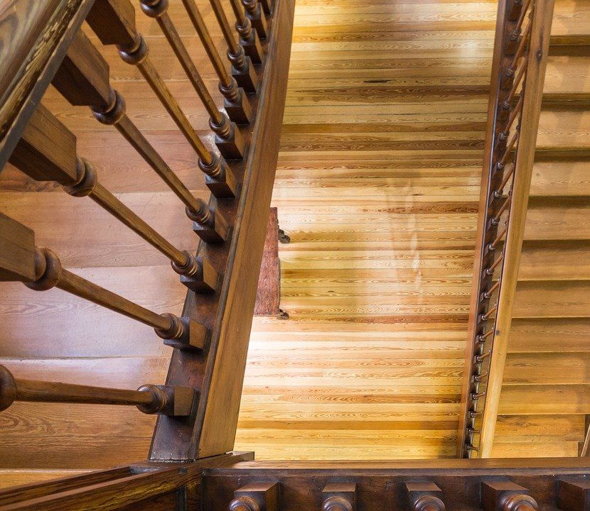 Looking up at a wooden staircase with a metal railing