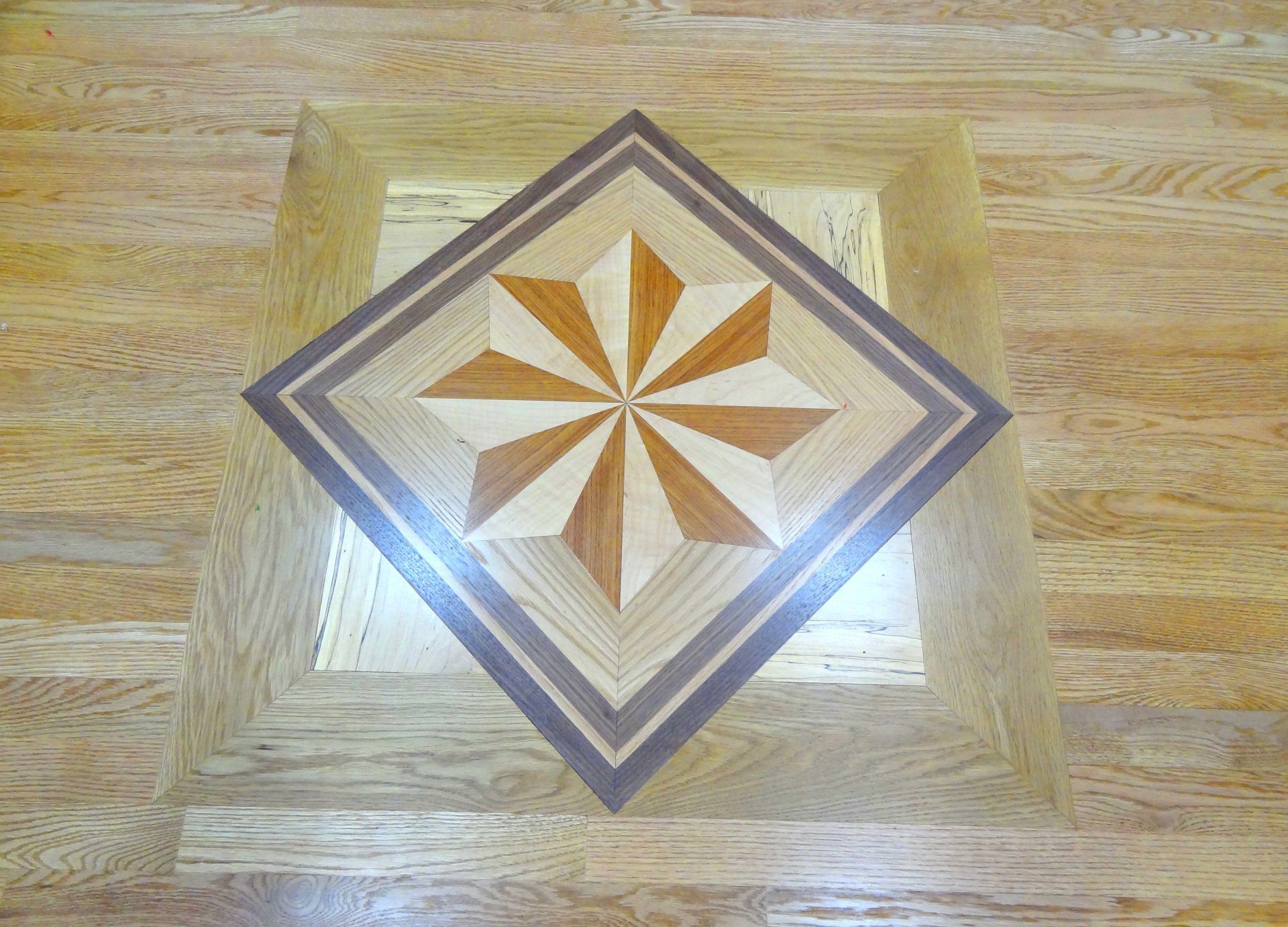 A wooden floor with a diamond shaped pattern on it