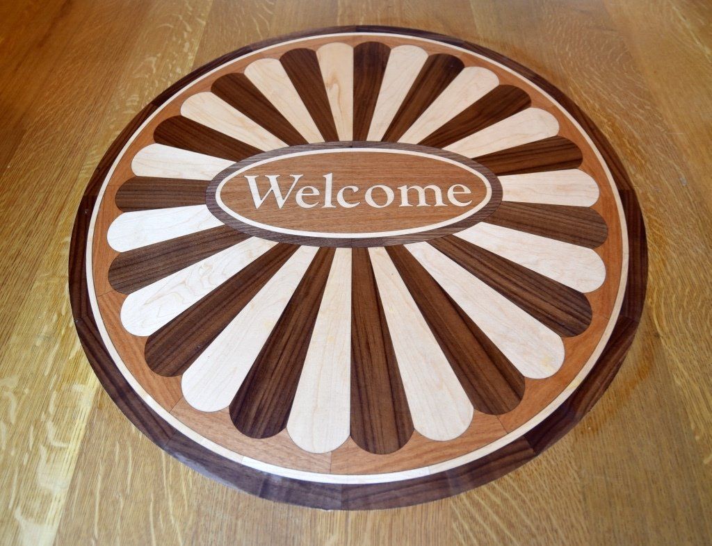 A wooden welcome sign on a wooden floor