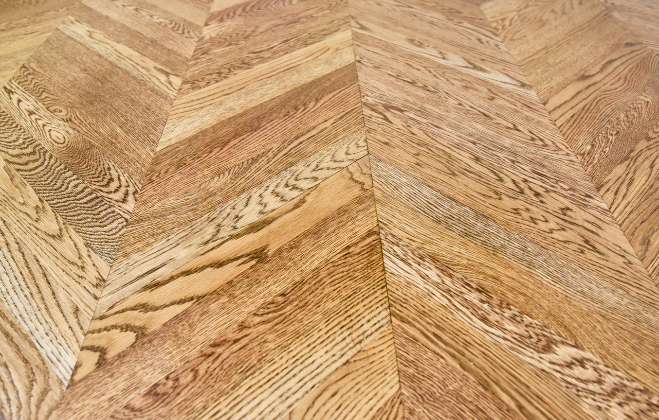 A close up of a wooden floor with a herringbone pattern