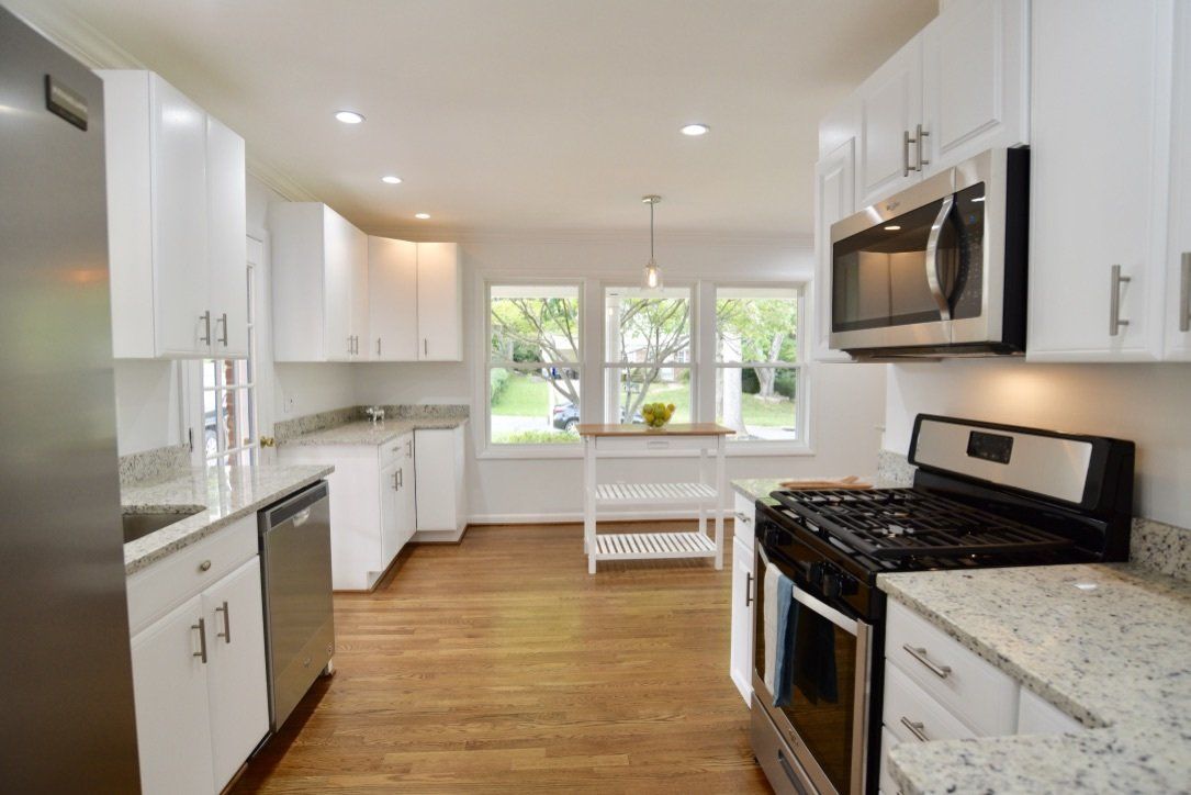 A kitchen with white cabinets and stainless steel appliances