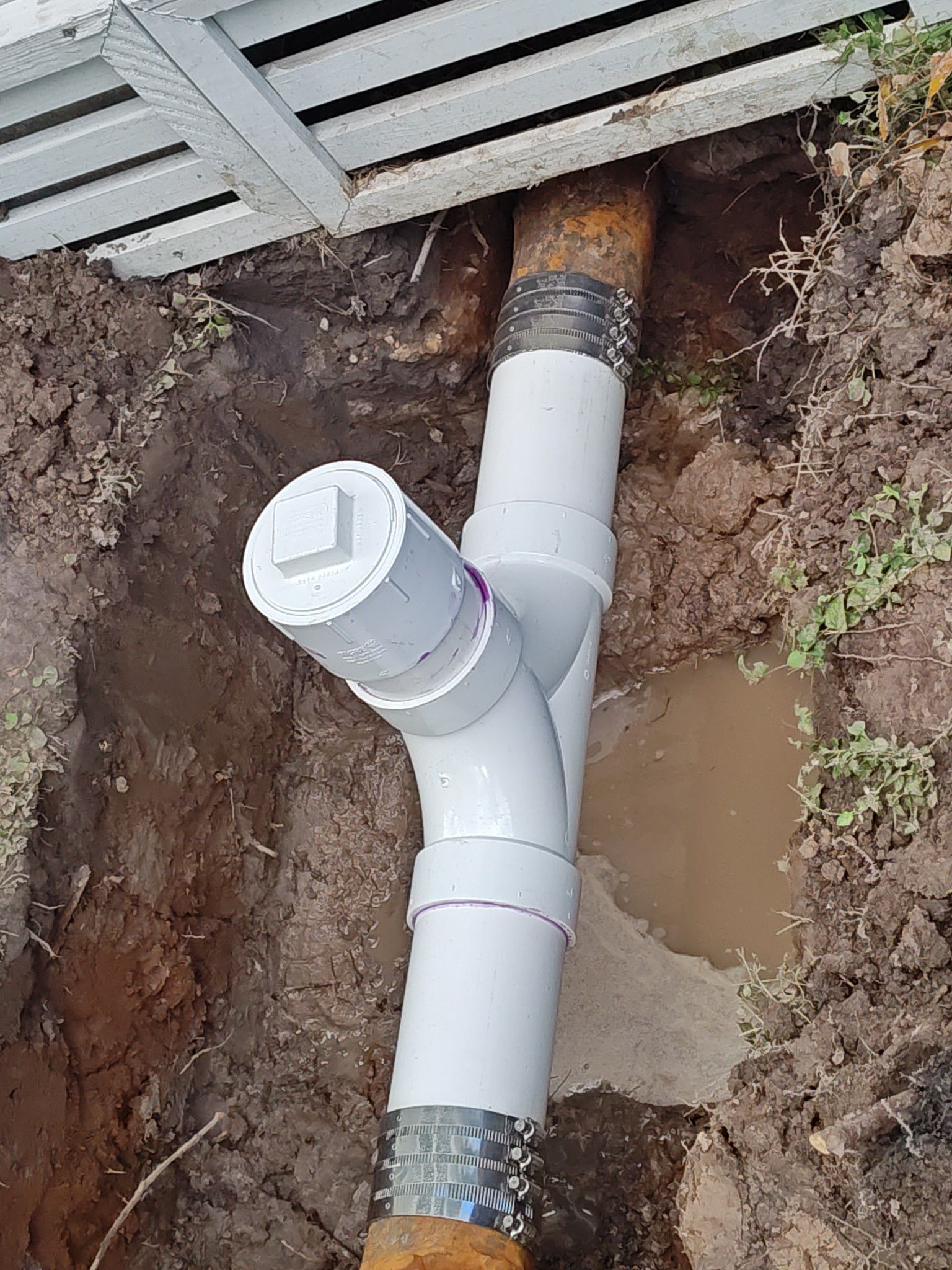 A drain pipe is being installed in a hole in the ground.