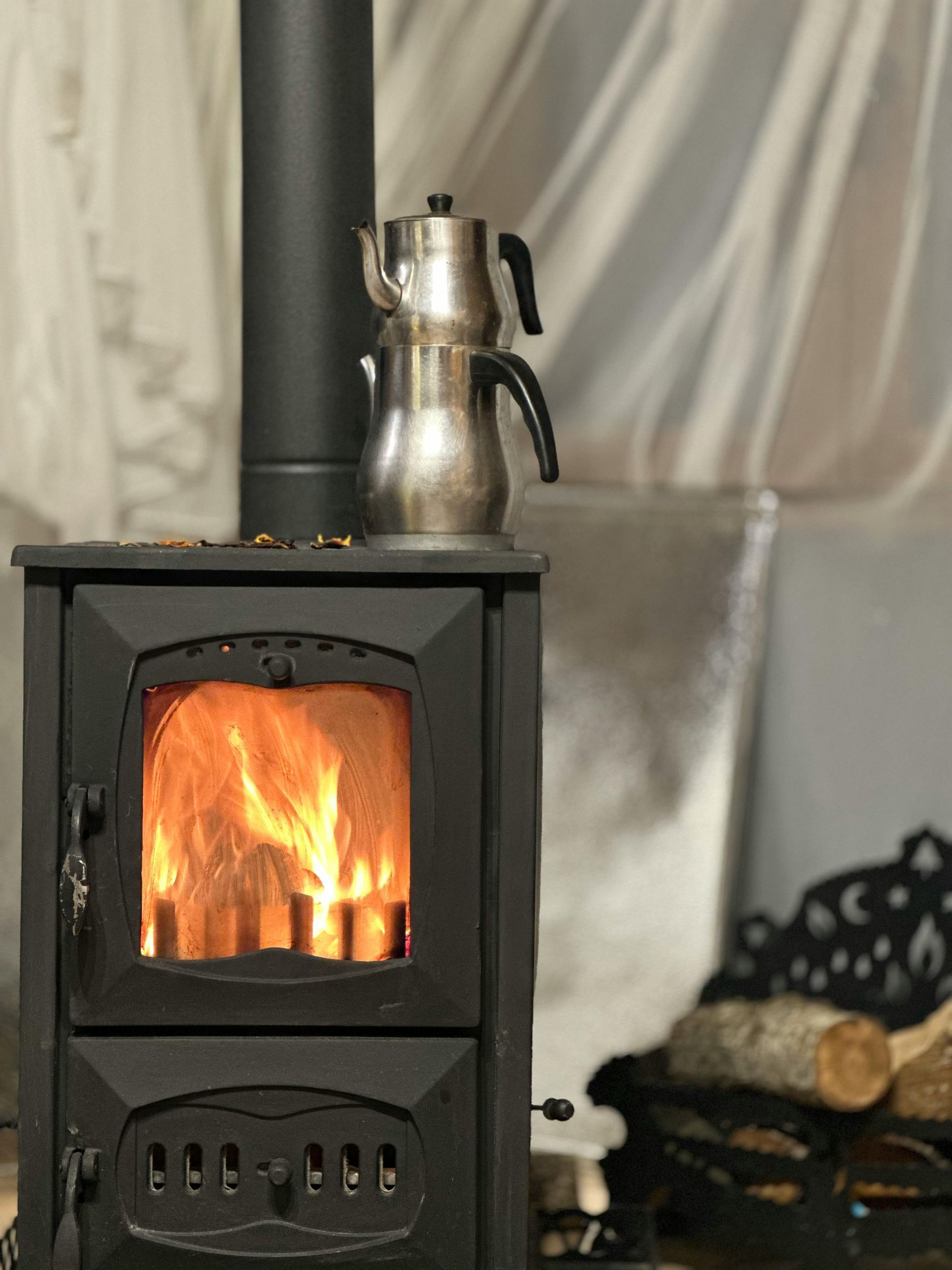 A wood stove with a teapot on top of it