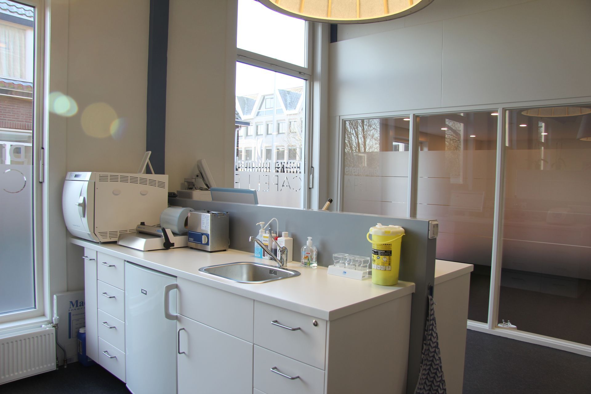 Badkamermeubel met wastafel, witte kastjes en een glazen douchecabine in een modern interieur.