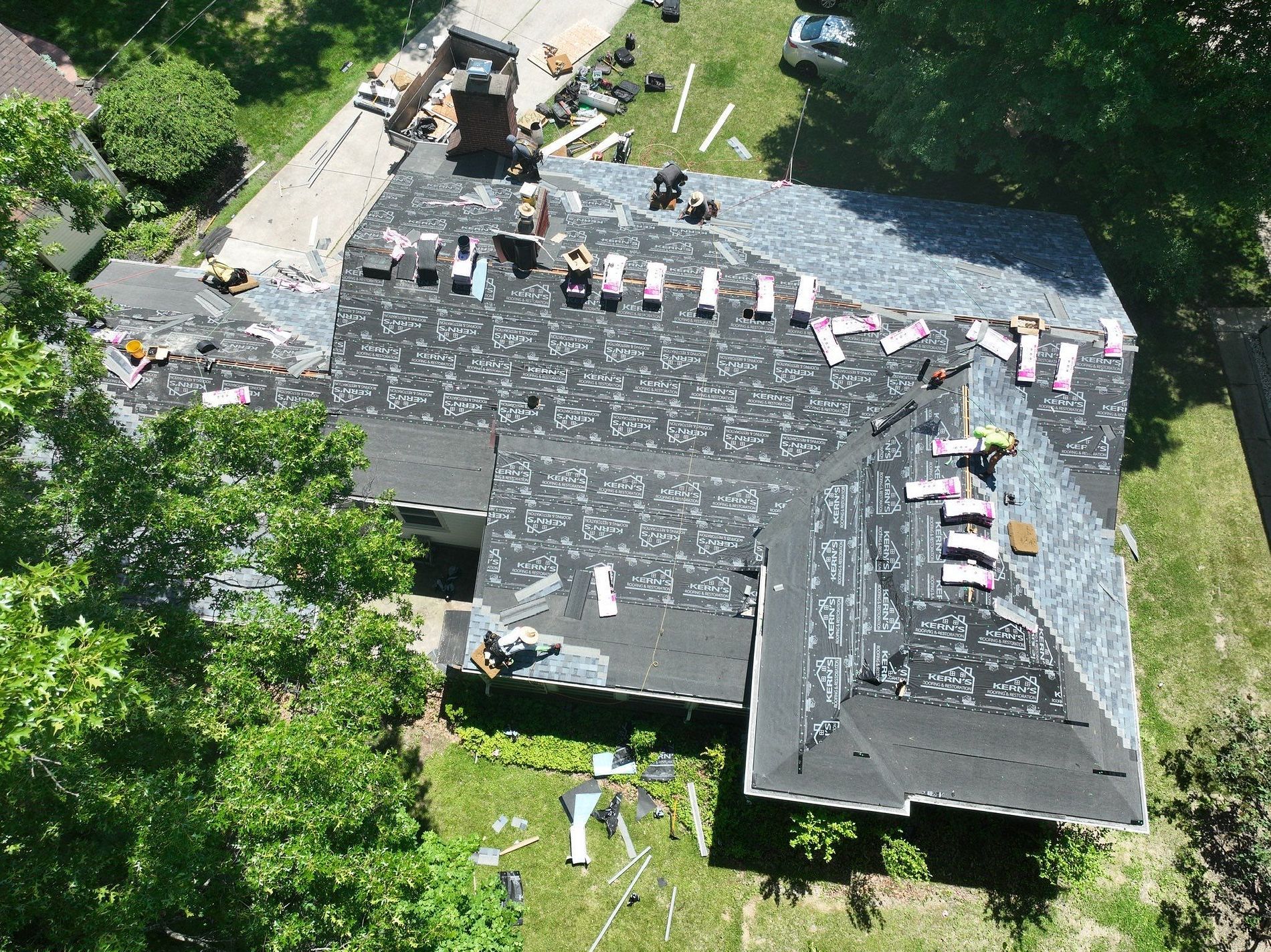 A group of people are working on the roof of a house.