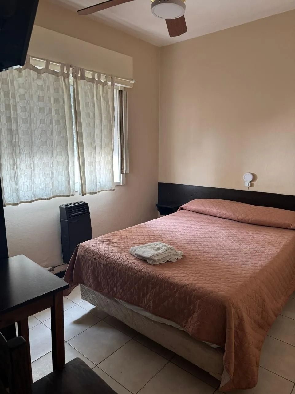 Un dormitorio con una cama que cuenta con un edredón texturizado de color melocotón