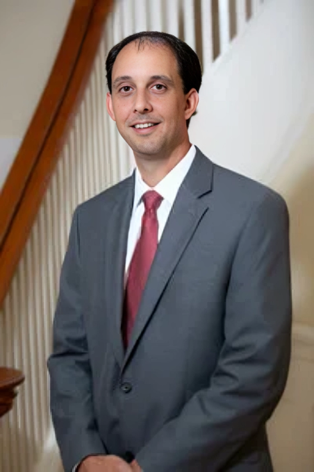 A man in a suit and tie is smiling for the camera.