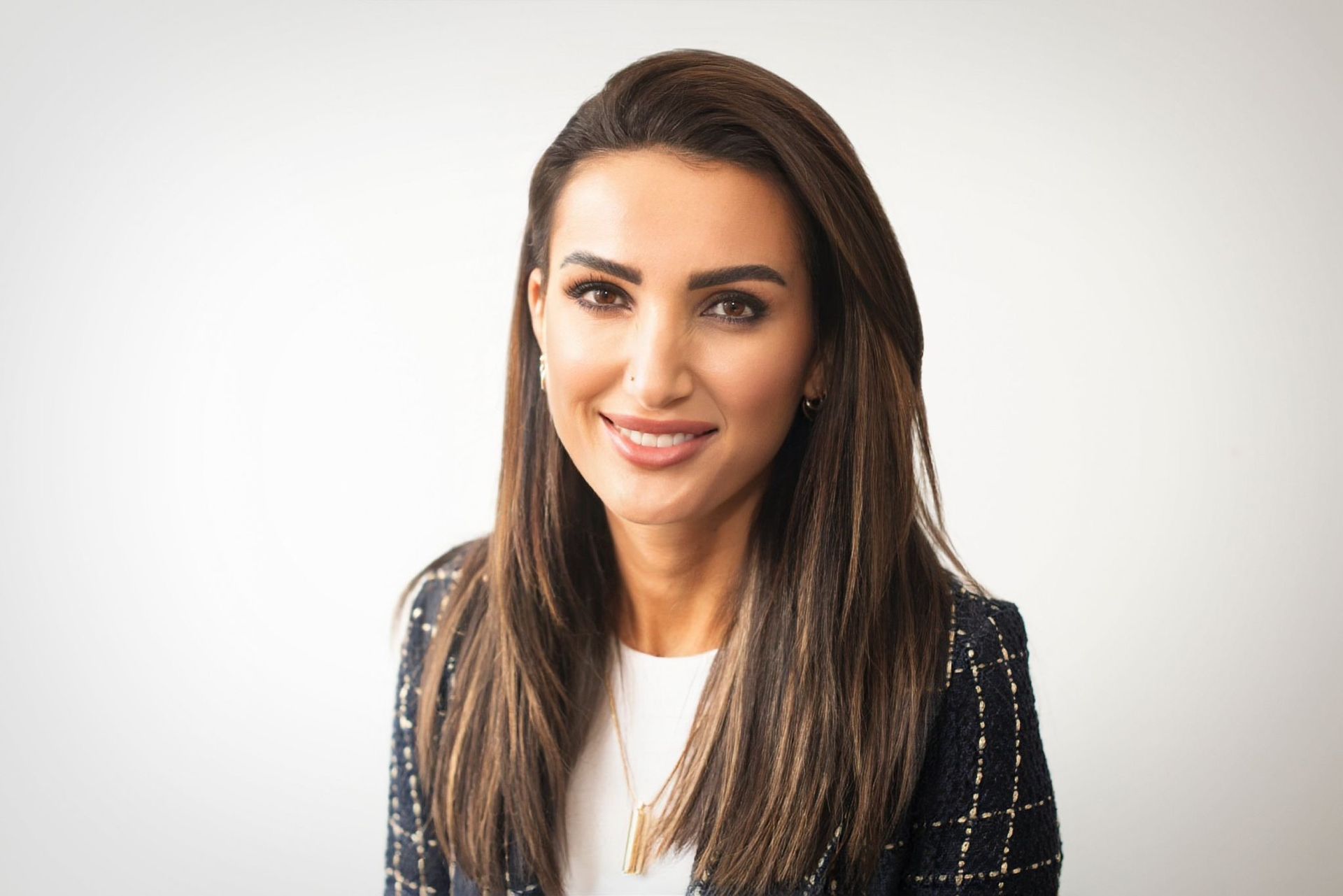 A woman with long brown hair is smiling for the camera.