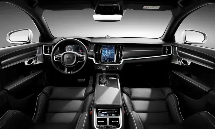 Black leather car backseat with headrests and a center armrest.