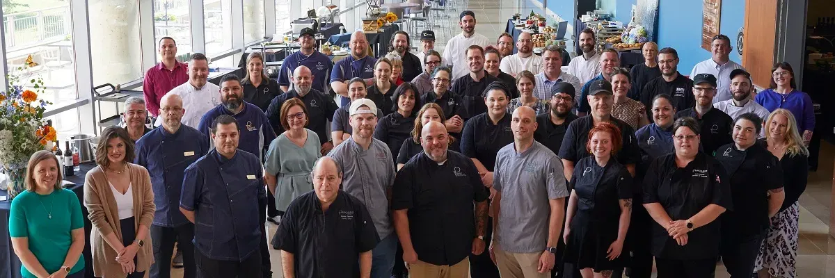 A large group of people are posing for a picture in a room.