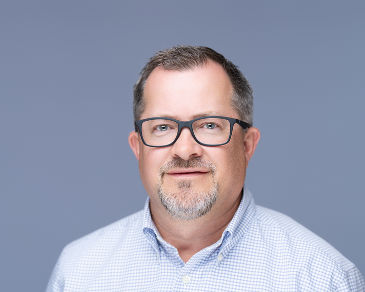 Confident corporate headshot of a male entrepreneur with studio lighting