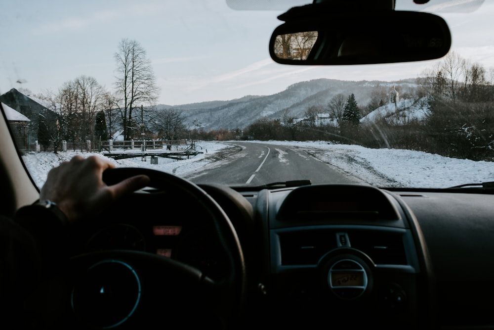 A person is driving a car down a snowy road.