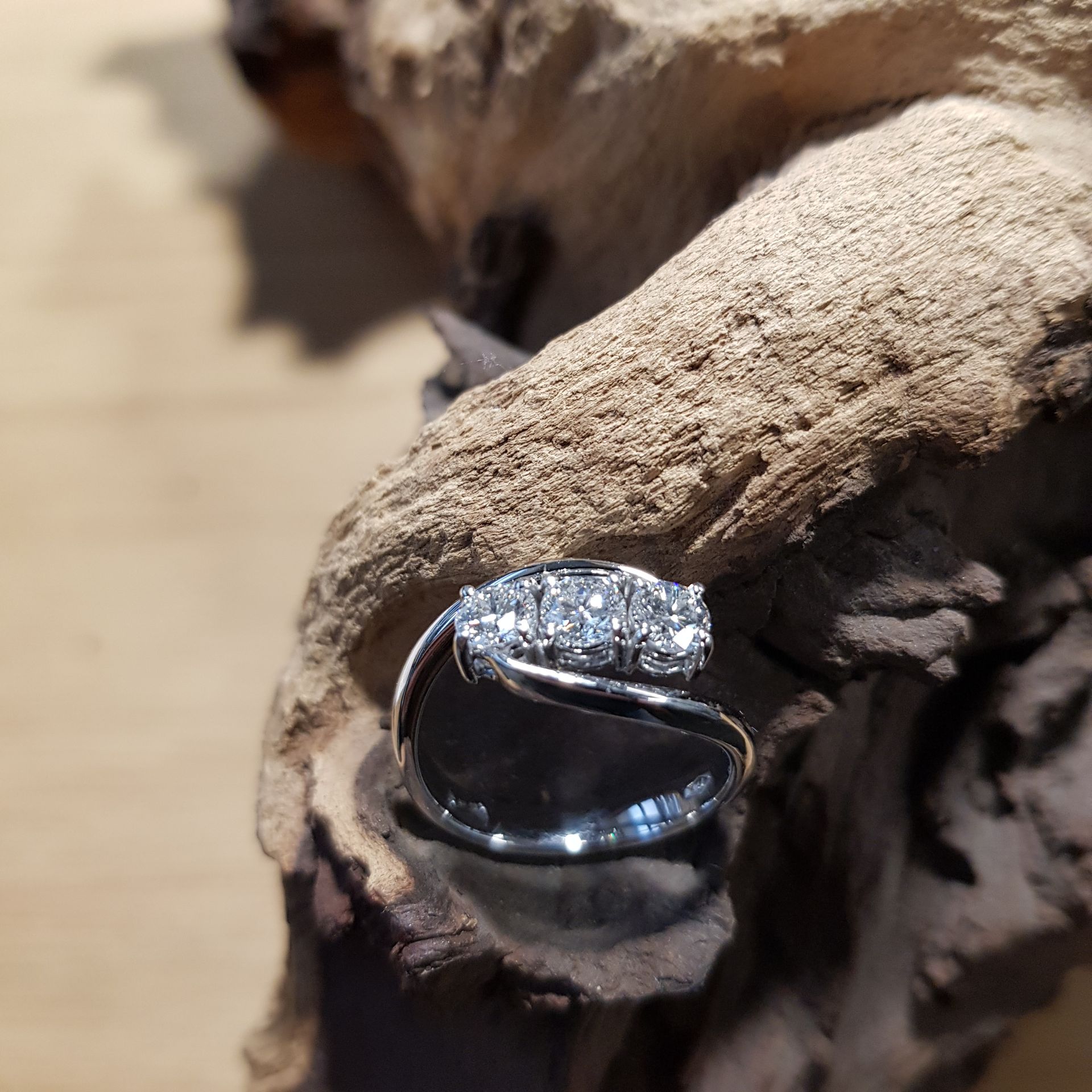 Due anelli d'oro su una scatola nera, un anello ondulato davanti e un anello aperto dietro.