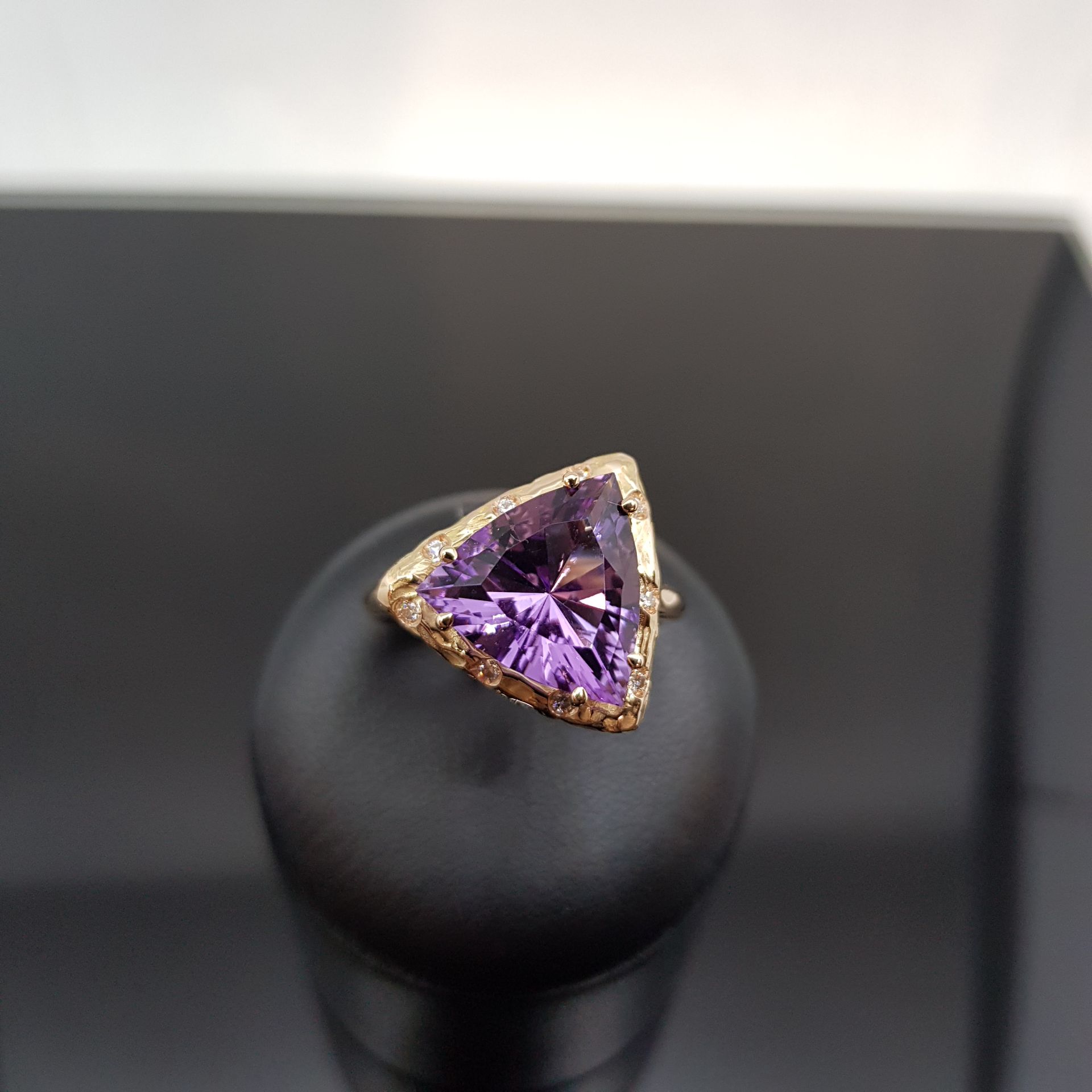 Ciondolo in opale blu con catena in argento, esposto su un supporto nero.