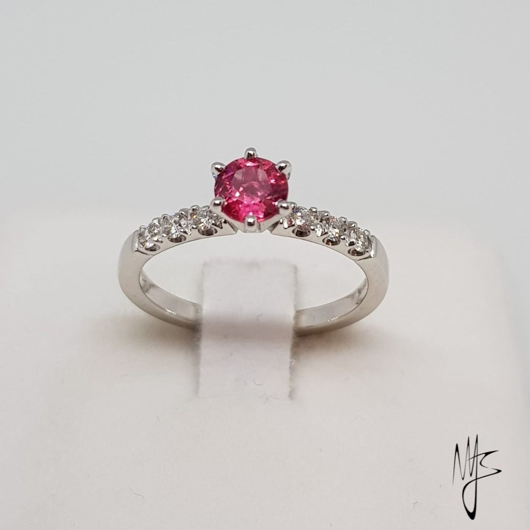Anello in argento con pietra preziosa rosa al centro e piccole pietre bianche sulla fascia.