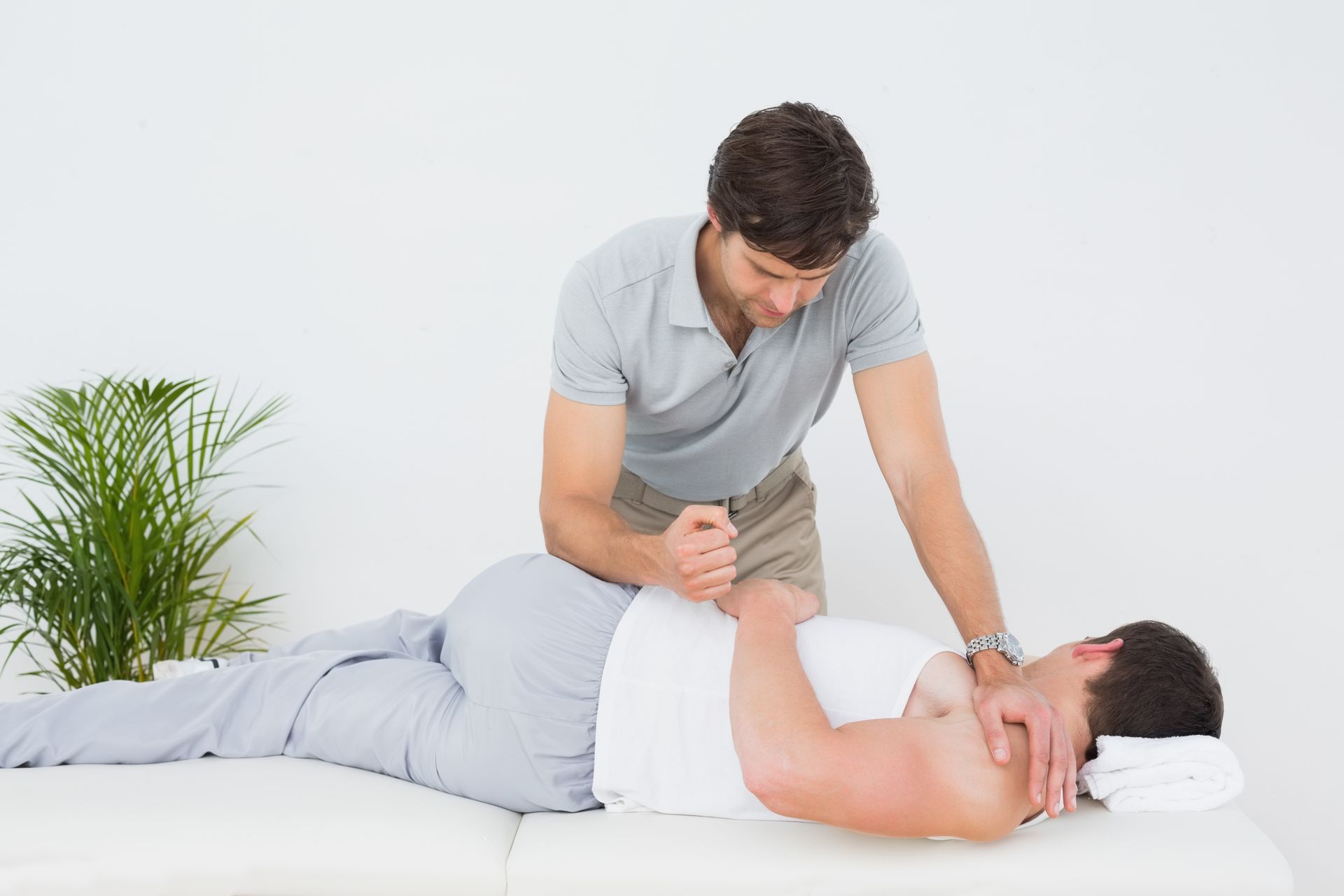 A man is giving a man a massage on a bed.