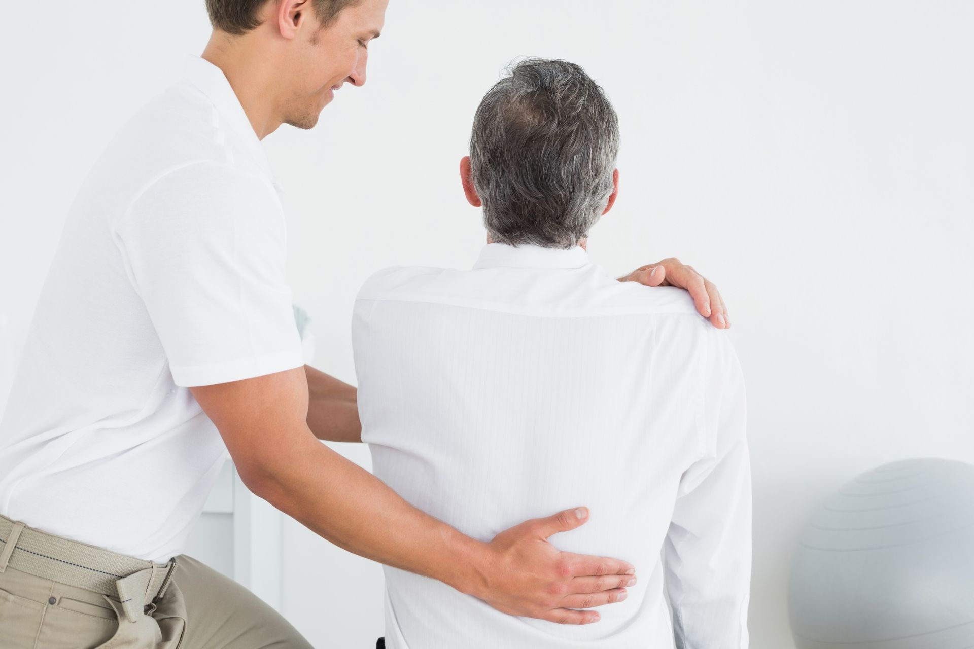 A man is giving a man a massage on his back.