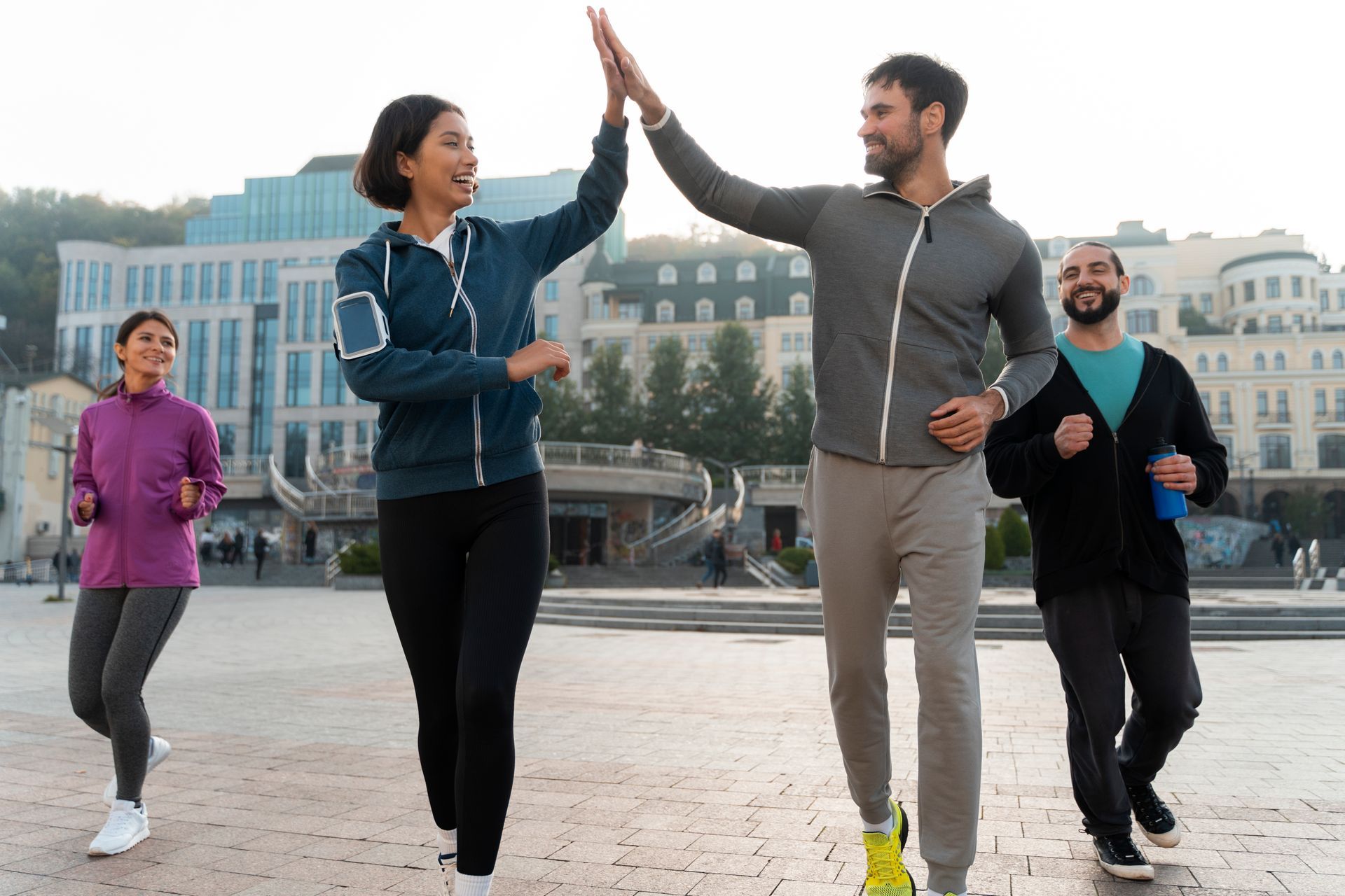A group of people are giving each other a high five while walking in the city.