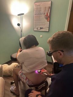 A woman is getting a physical therapy treatment on her shoulder.