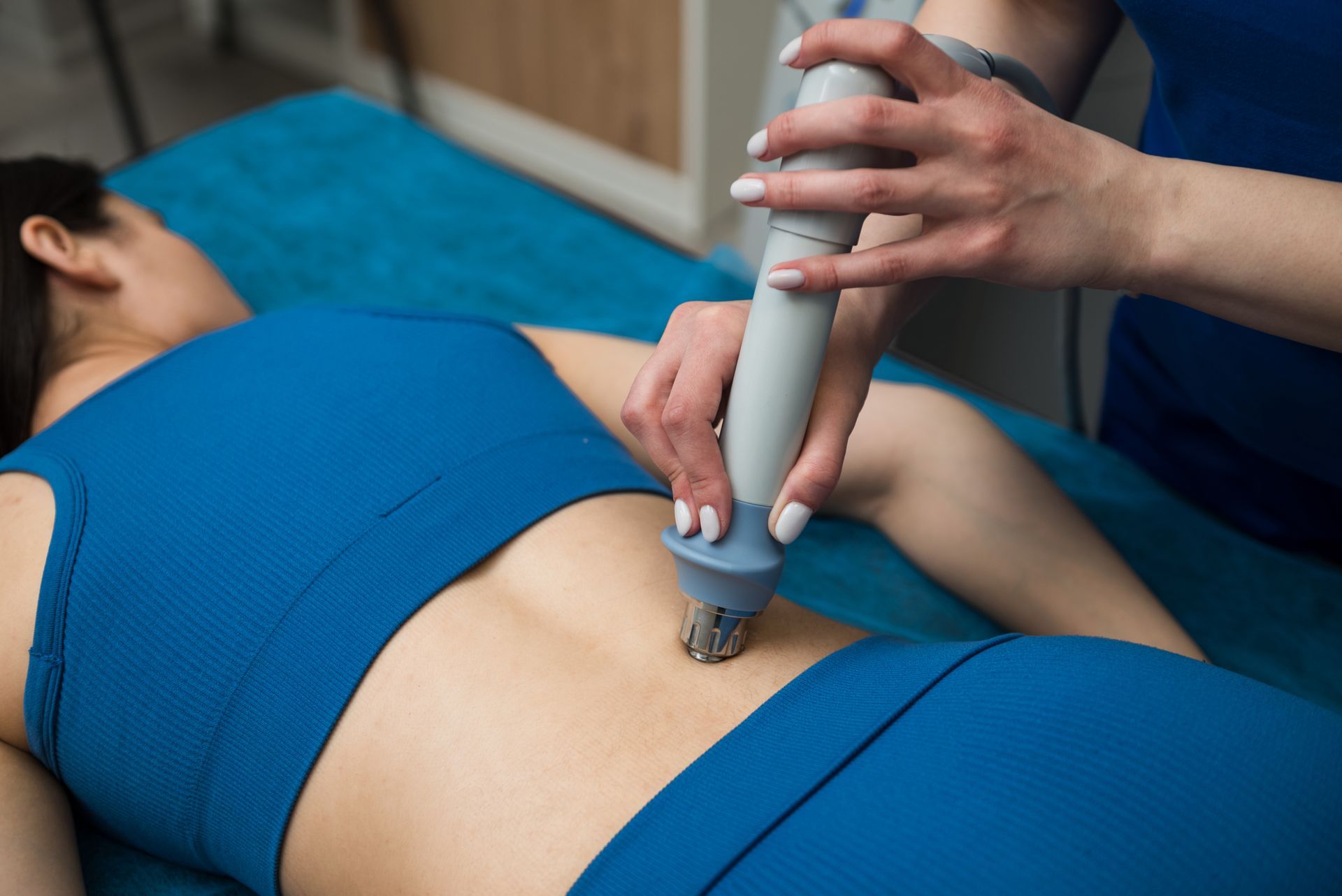 A woman is laying on a bed getting a massage on her back.