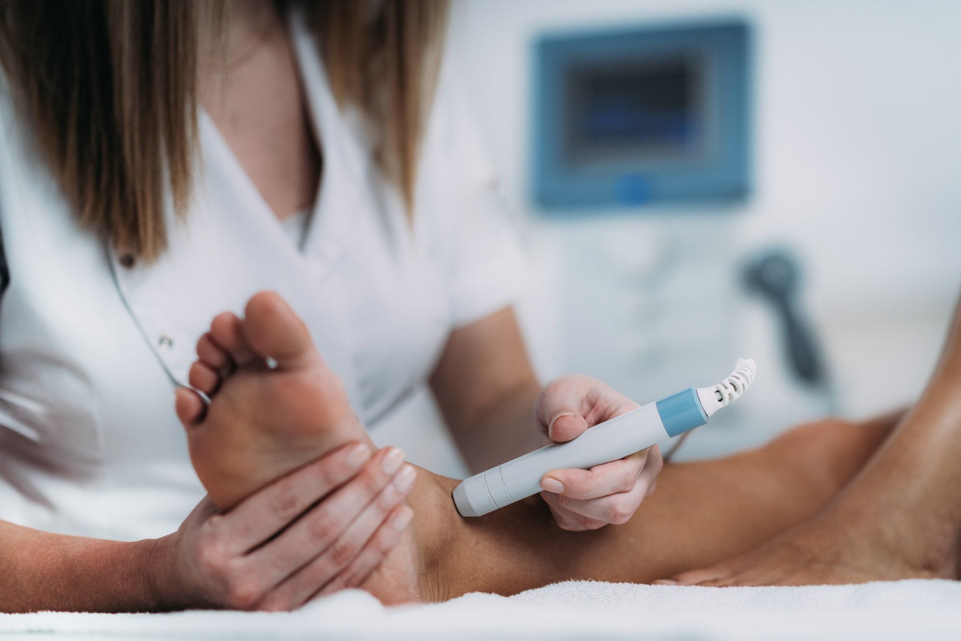 A woman is giving a foot massage to a patient.