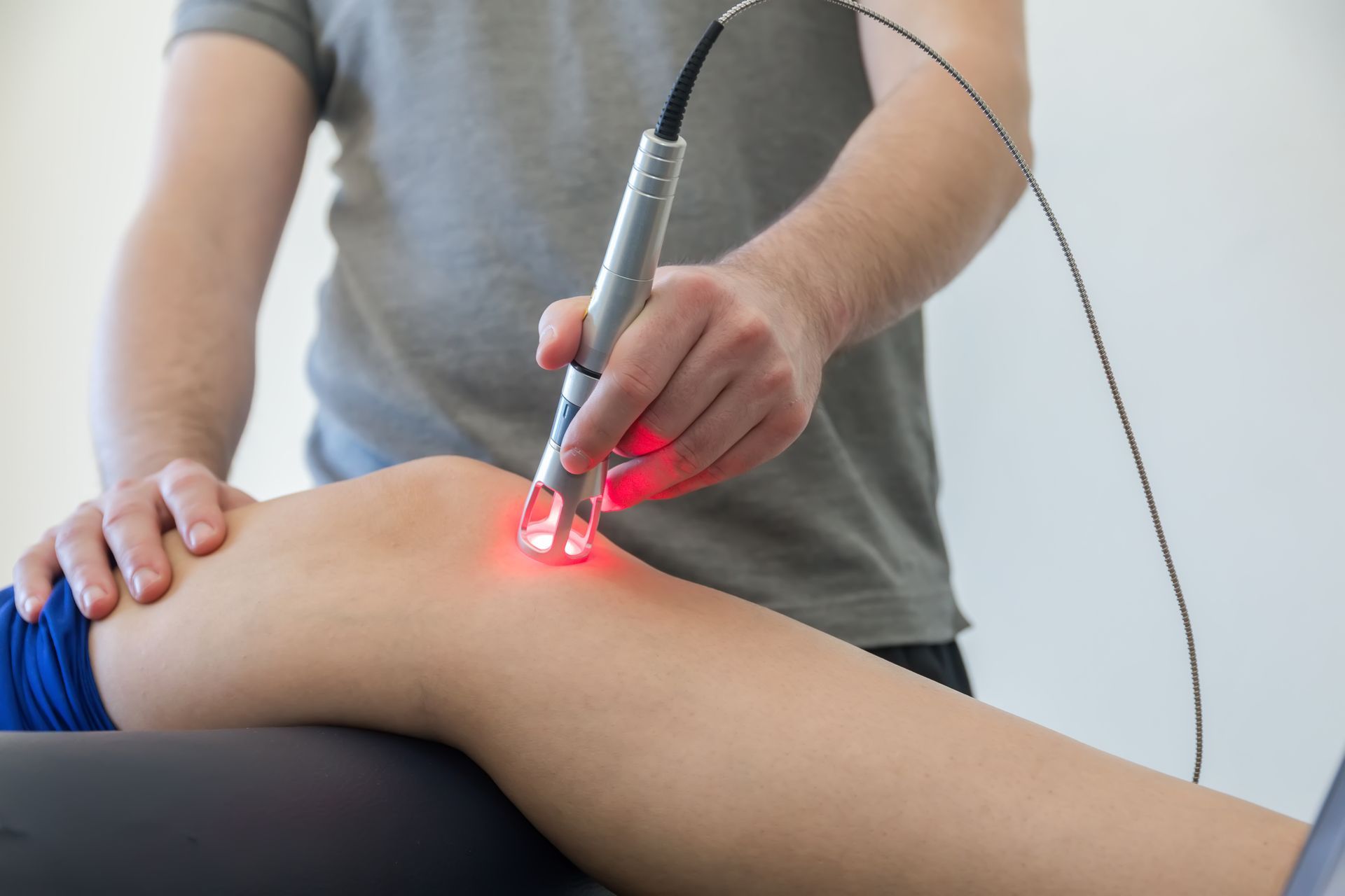 A person is getting a laser treatment on their knee.