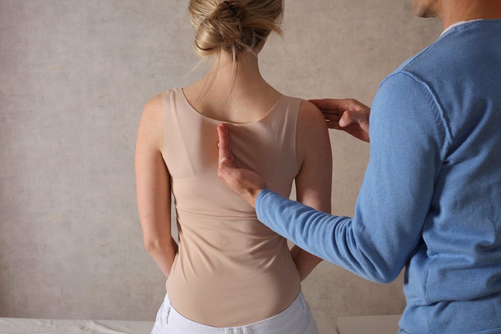 A man is examining a woman 's back.