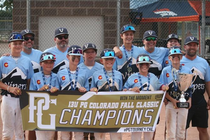 Baseball glove with ball on green grass, with blurred baseballs in the background.