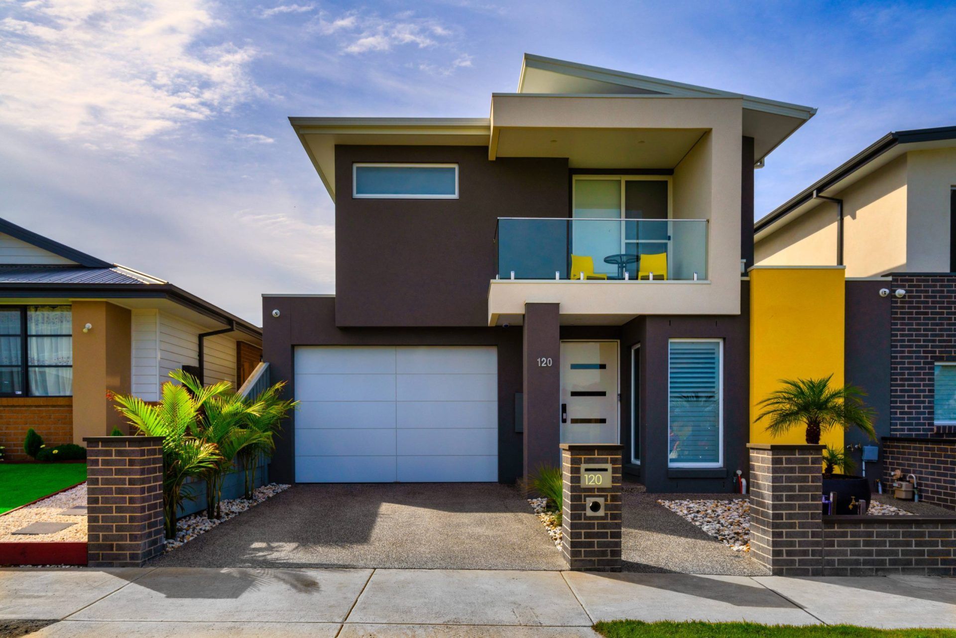 White modern roller door on two storey brown house