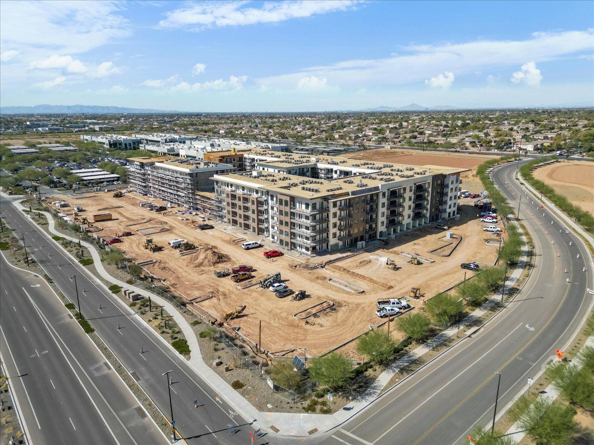 An aerial view of a large building under construction next to a highway.