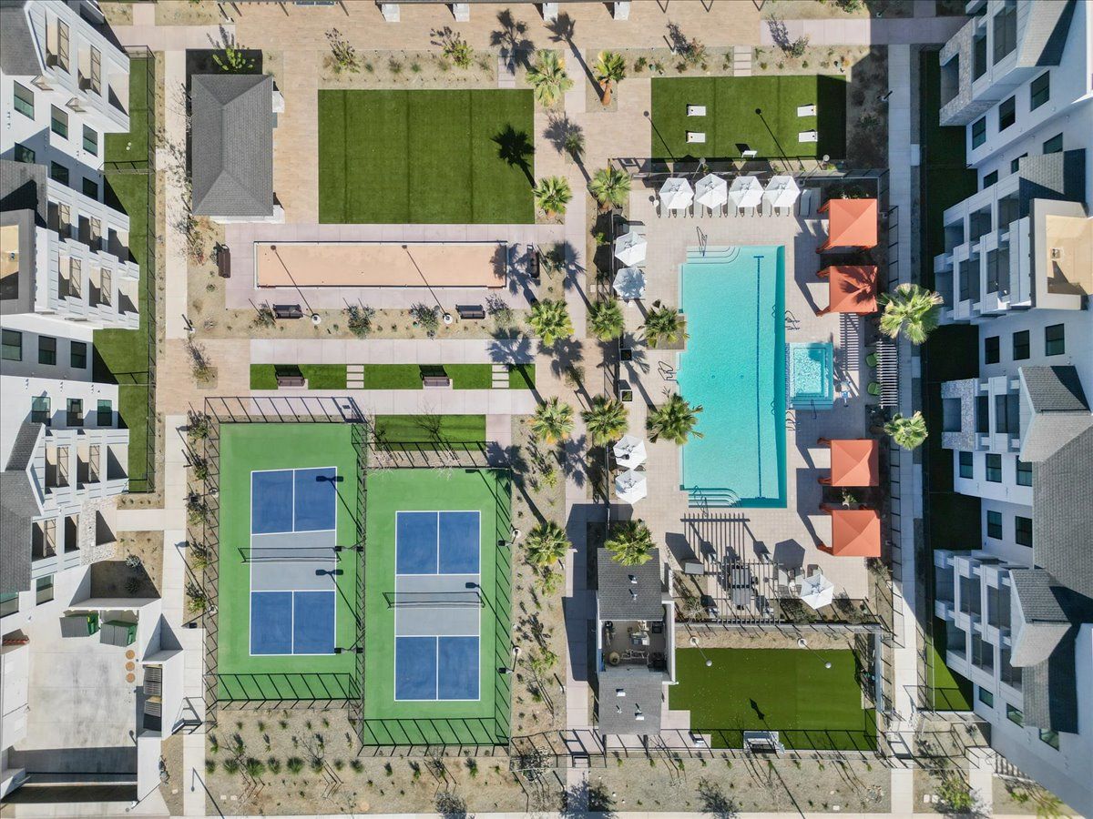 An aerial view of a building with tennis courts and a pool