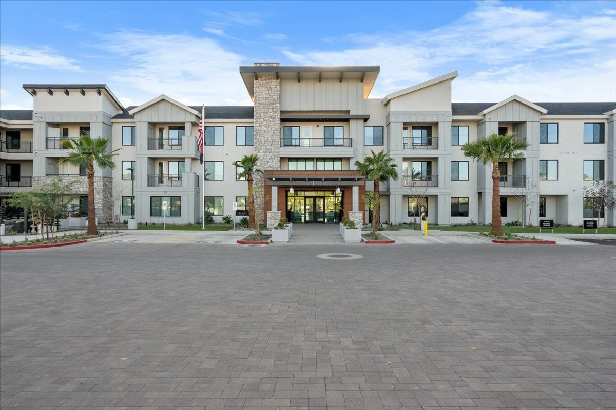 A large apartment building with palm trees in front of it