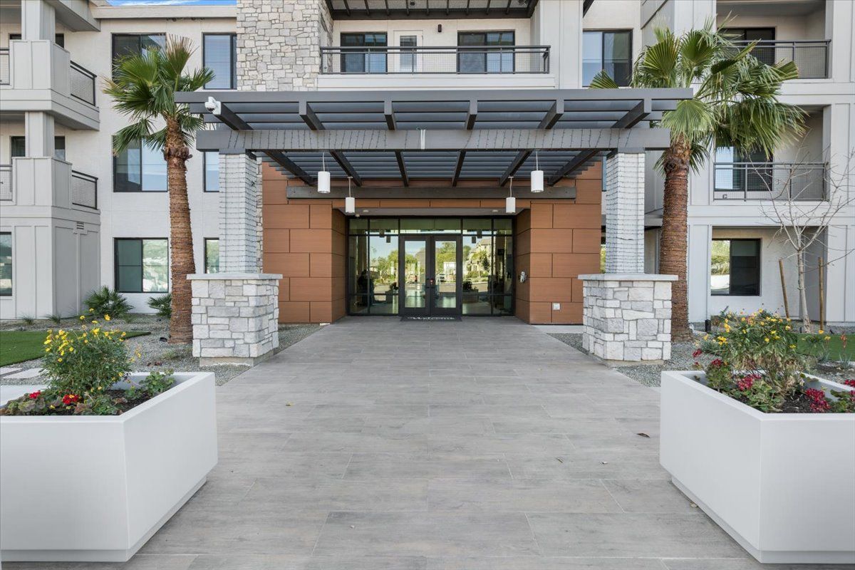 The entrance to a building with palm trees in front of it