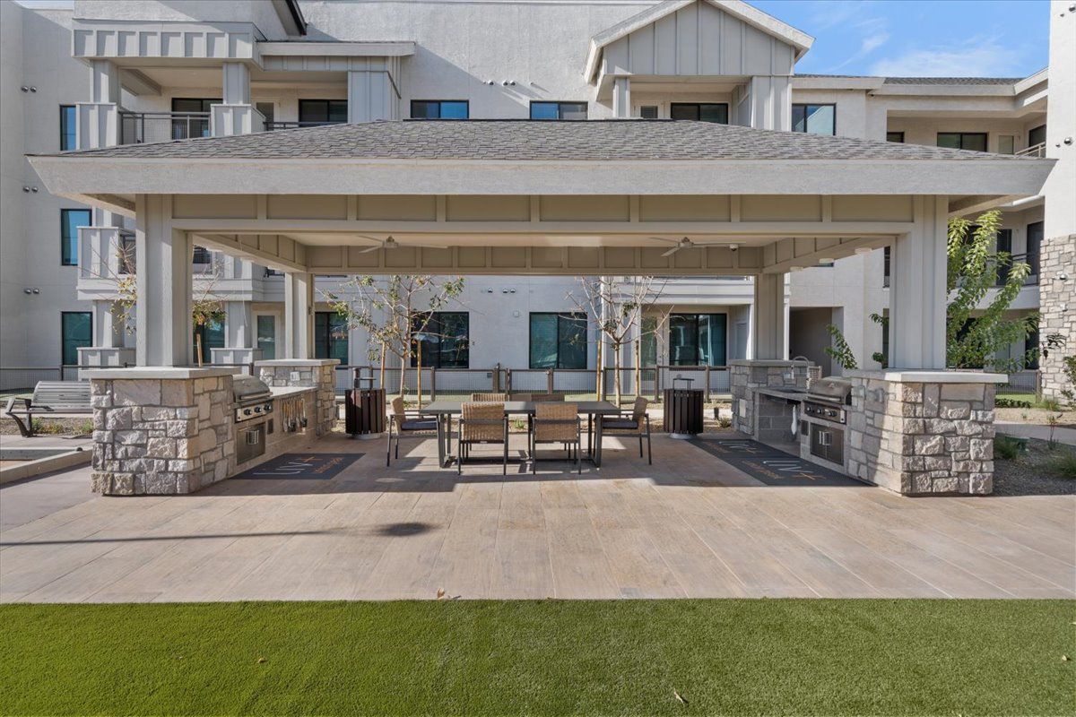 A large white building with a covered patio area in front of it.