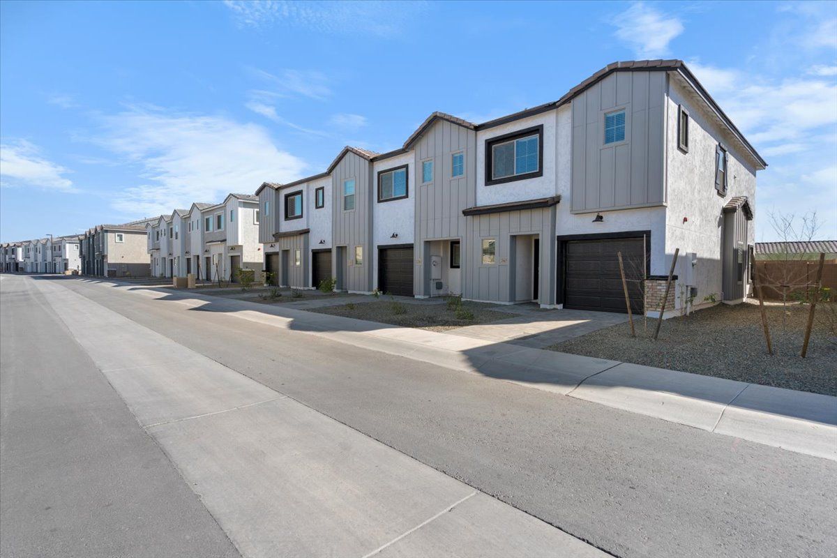 A row of houses sitting next to each other on the side of a road.