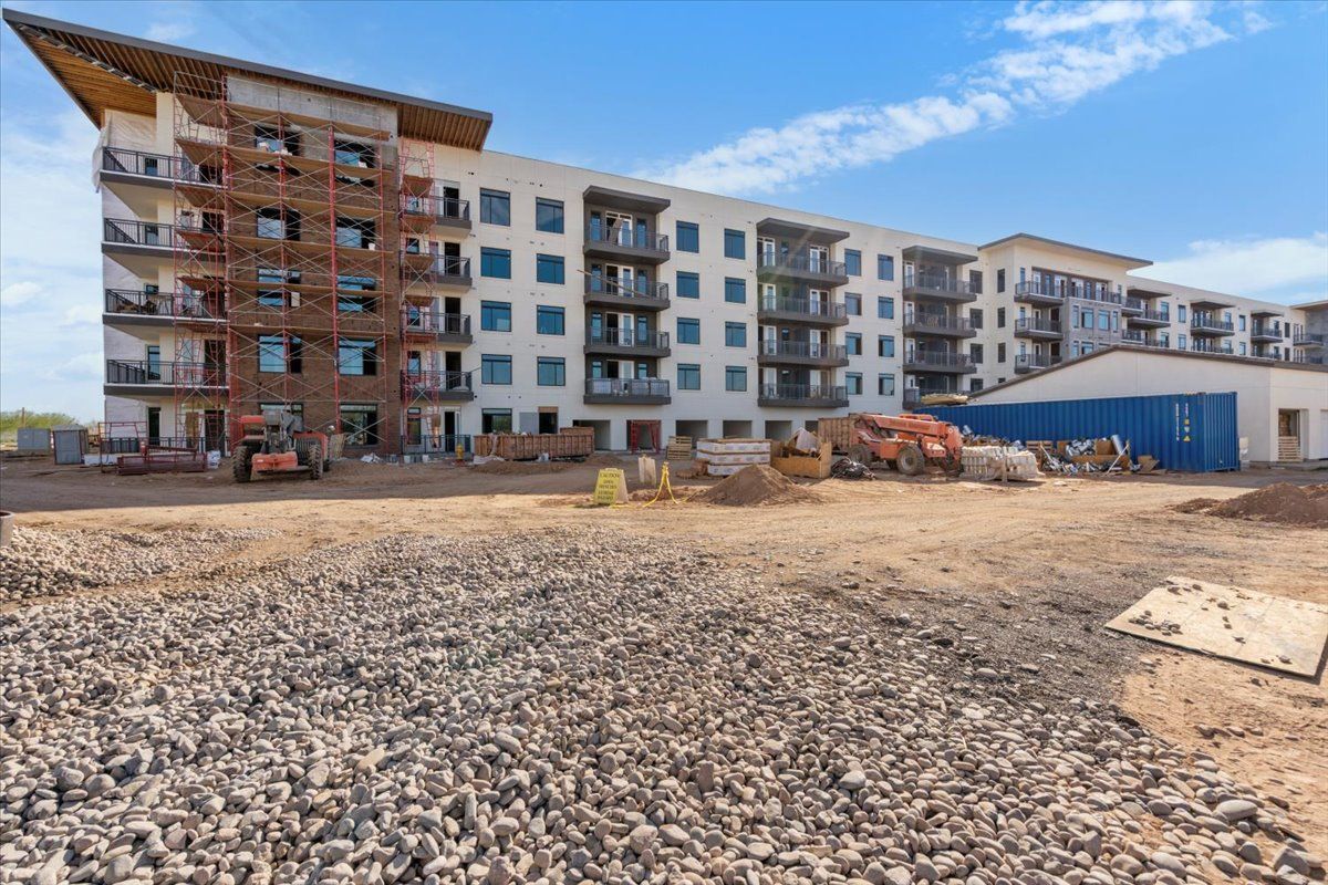 A large building is being built next to a pile of gravel.
