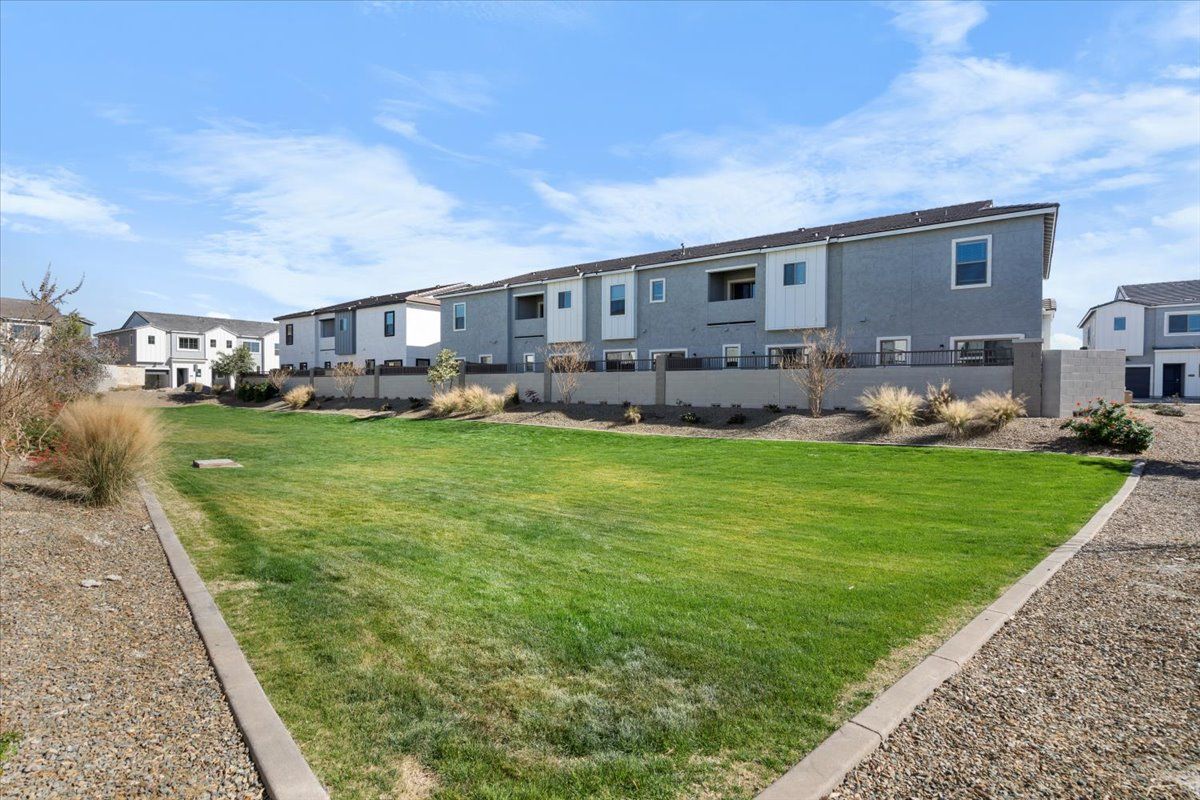 A row of houses with a large lawn in front of them.