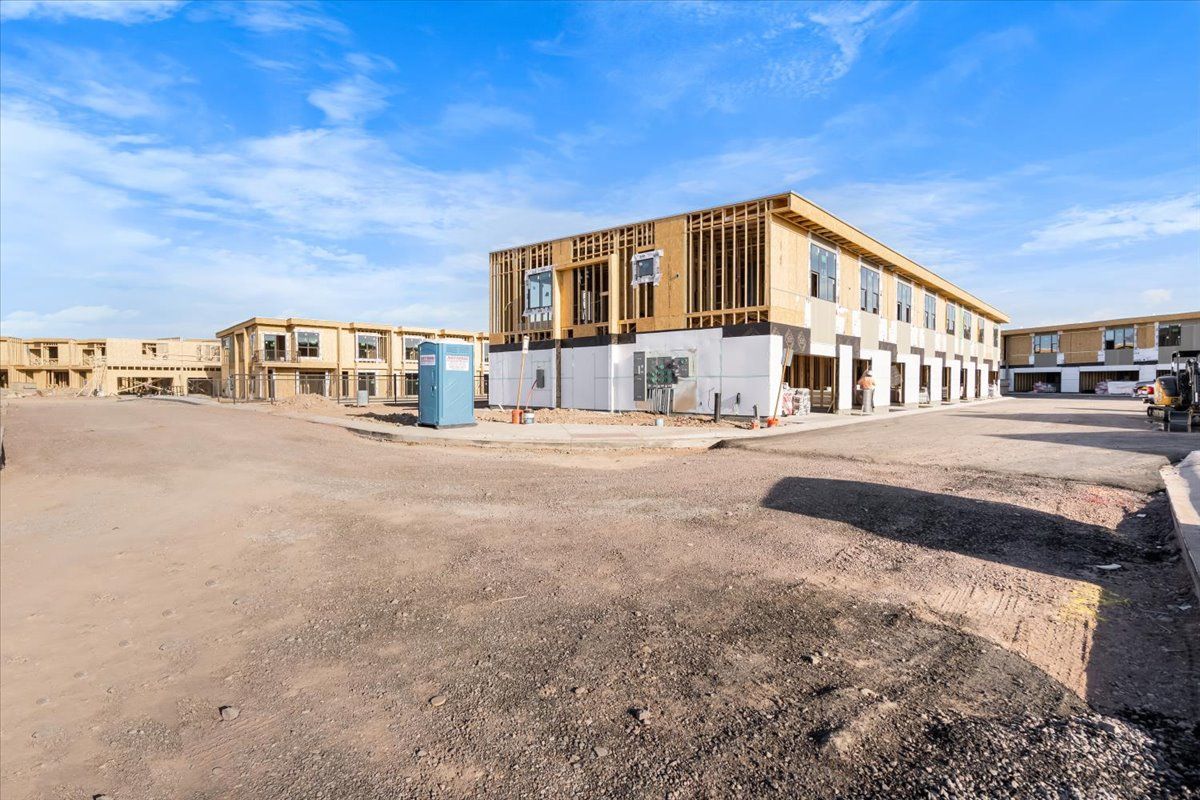 A large building is being built in the middle of a dirt field.